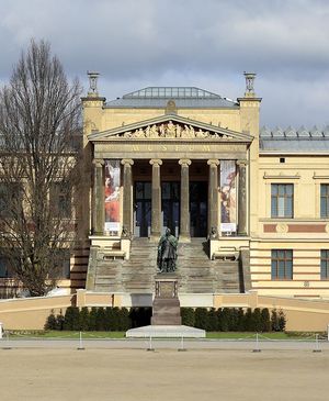 Die Frontansicht des Museums zeigt das Eingangsportal mit ionischen Säulen und einer großen Treppe.