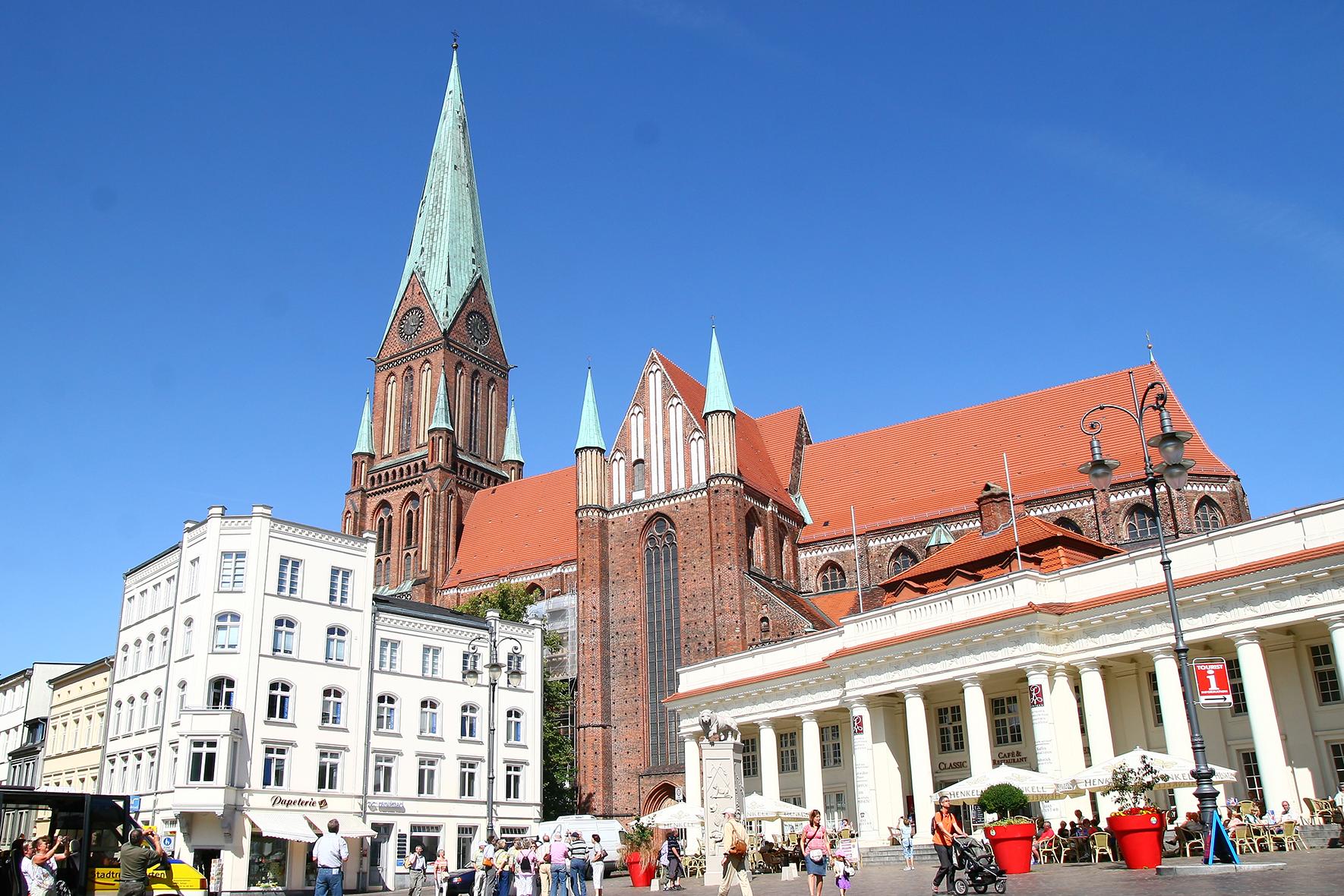 Vom Marktplatz aus betrachtet überragt der Schweriner Dom im Stil der Backsteingotik andere vorstehende Gebäude.  