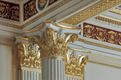 Eine Nahaufnahme der korinthischen Säulen im Ballsaal zeigt die reiche Verzierung durch goldene Ornamente.