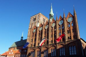 Die Fassade des Rathauses in Stralsund ist von den Flaggen Europas, Mecklenburg-Vorpommerns und Stralsunds geziert.